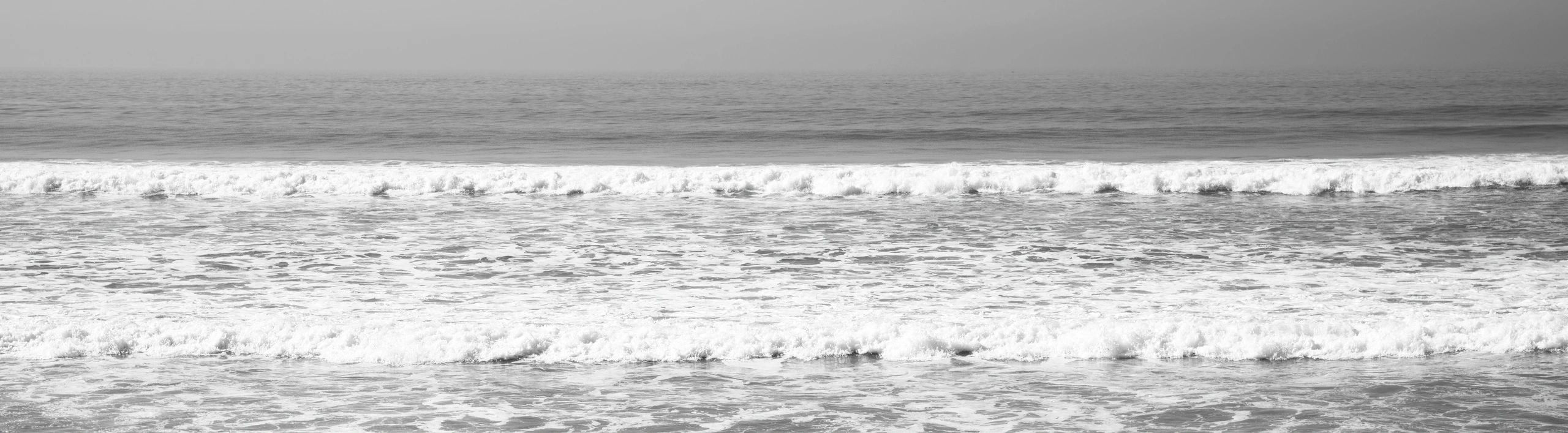 Empty surf beach at sunrise with rolling Atlantic-style waves