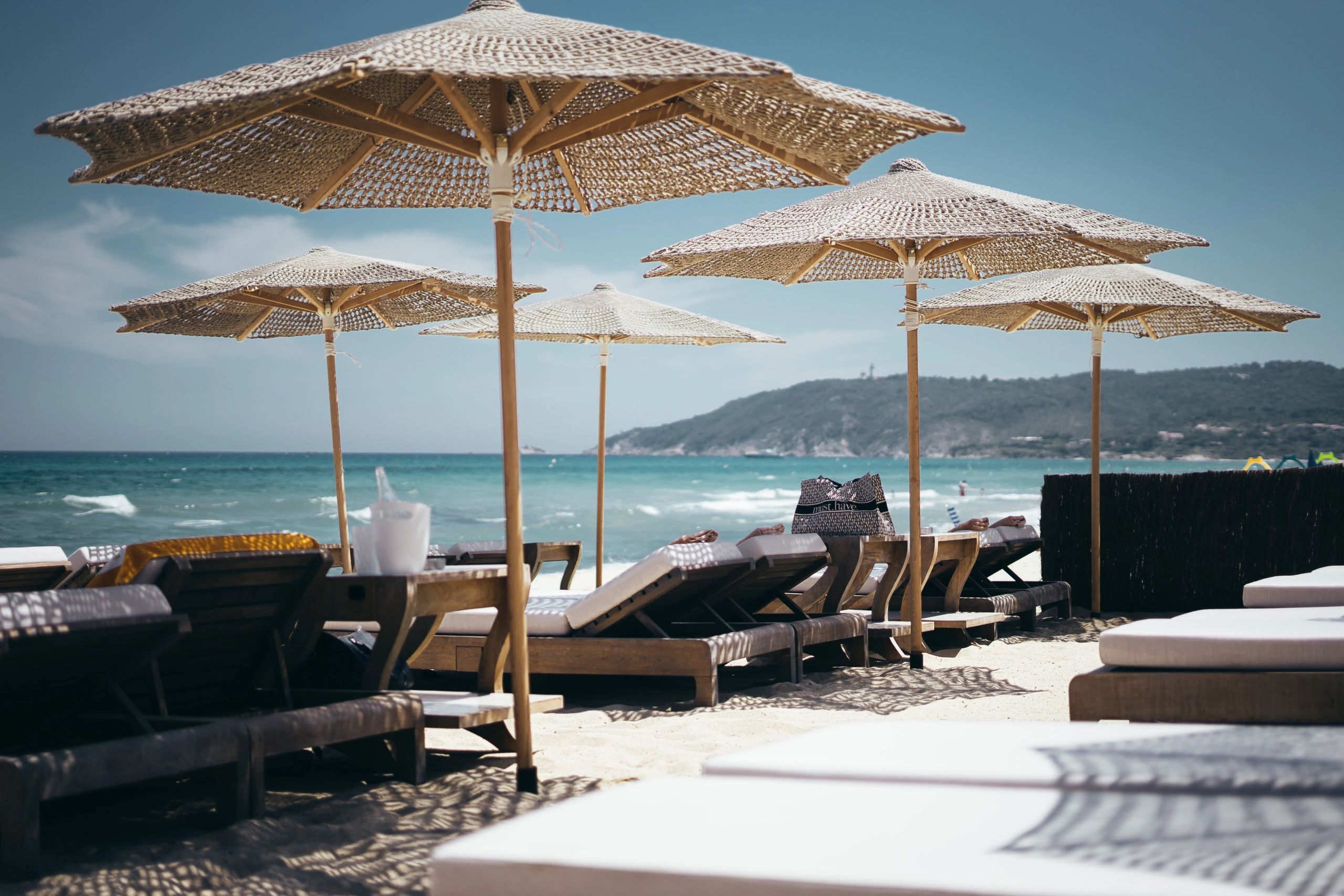 Empty beach loungers under umbrellas