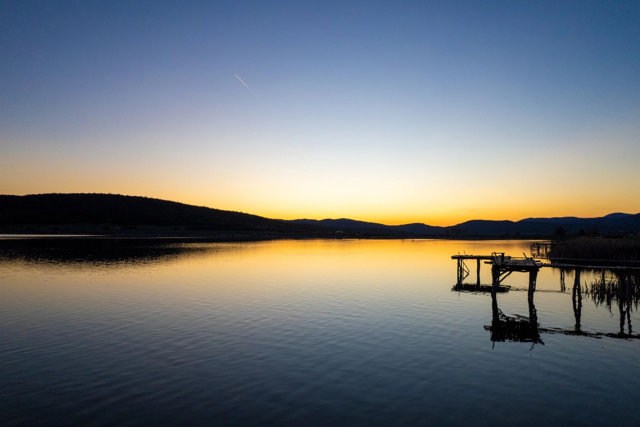Wooden pier at sunset with calm water
